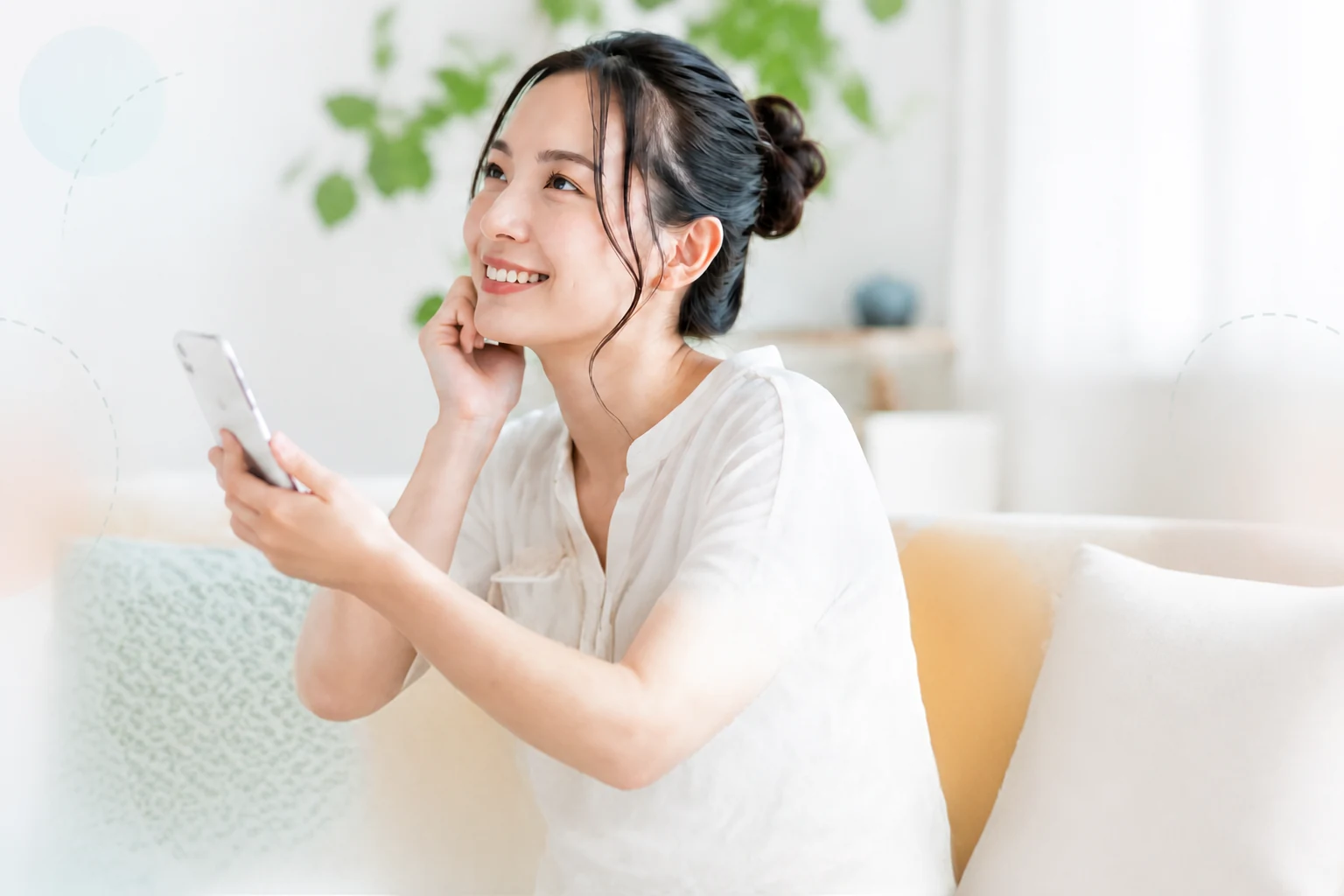 スマートフォンを持って微笑む女性